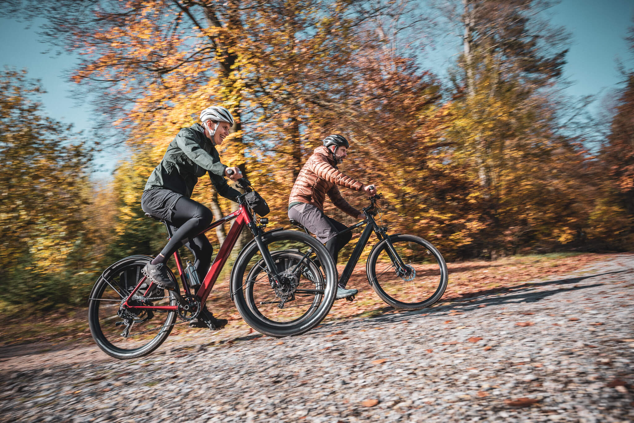 Mann und Frau fahren auf leichten Trekking E-Bikes von Coboc durch den Wald