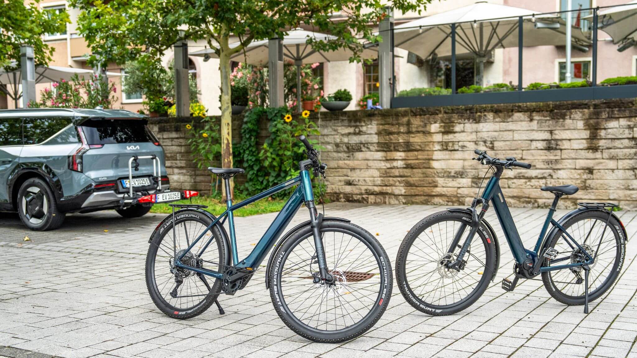Coboc E-Bikes Skye und Skye Step stehen in der Stadt neben Kia EV9