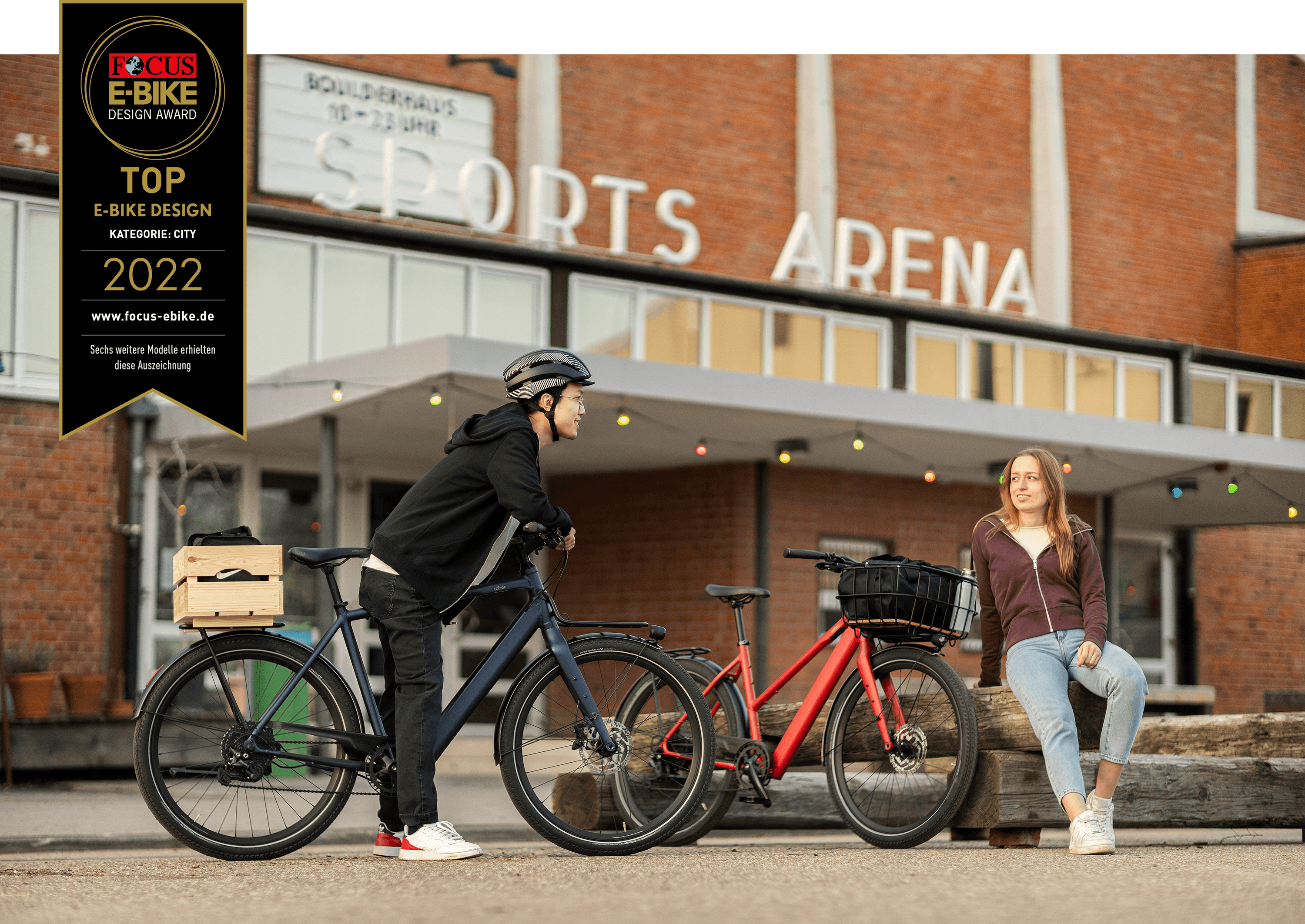 Ein Mann auf einem leichten E-Bike mit Frontgepäckträger spricht mit einer Frau, diese sitzt neben dem Bristol von Coboc